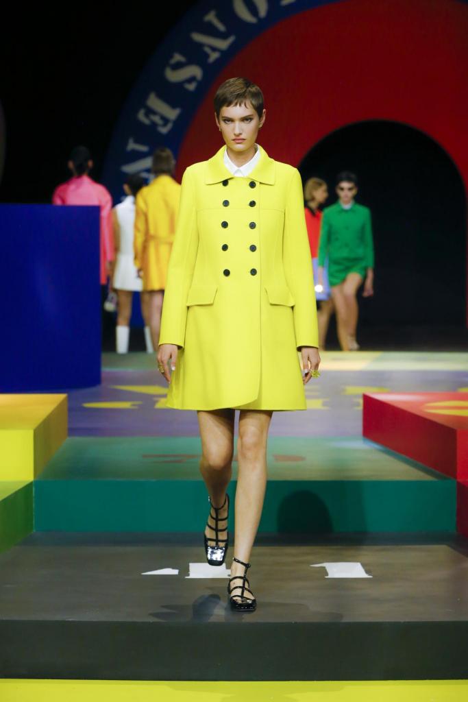 Sixties moodKorte knalgele mantel, met een knipoog naar de sixties, van Dior (prijs niet meegedeeld).