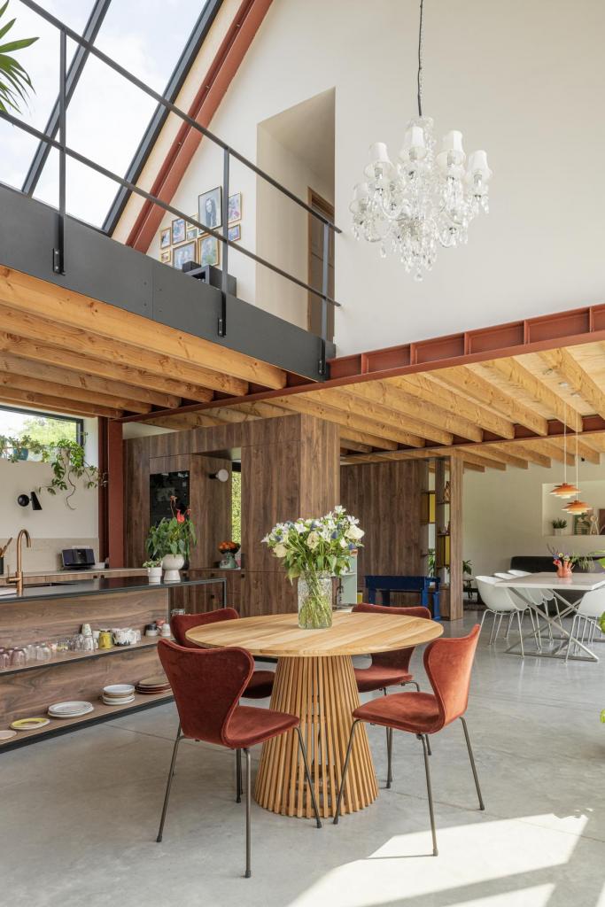 De dubbelhoge eetruimte en open keuken vormen het hart van de woning.