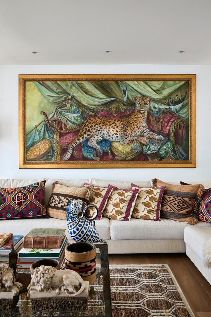 Het grote schilderij met een luipaard van Thierry Bosquet domineert de woonkamer. Op tafel staan kaarsen van Bahia Mala, het merk van Axelles dochter Emilie Gosse. 