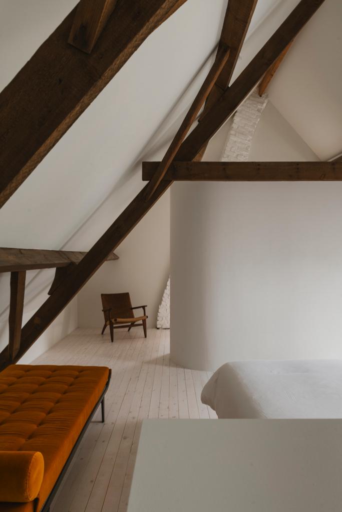 De slaapkamer is geheel verrassend minimalistisch, daar mocht alles sereen wit zijn. Zelfs de sanitaire capsule die Charles en zijn architectuurpartner Ngoc Hoang ervoor ontwierpen lijkt in de ruimte op te gaan.