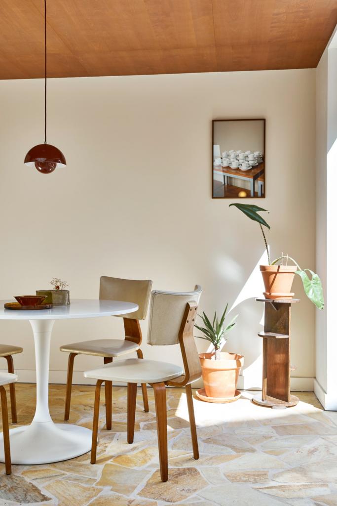 Het berkenfineer van de keukenkasten loopt door naar het plafond, waardoor je een cocon creëert.