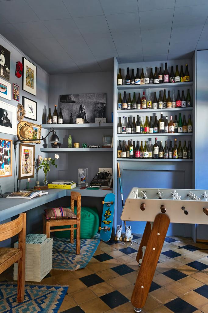 Het bureau met originele vloer is een pêle-mêle van kleinere kunstwerken en de bijzondere wijnflessen waar voor Bernard een verhaal aan vasthangt.