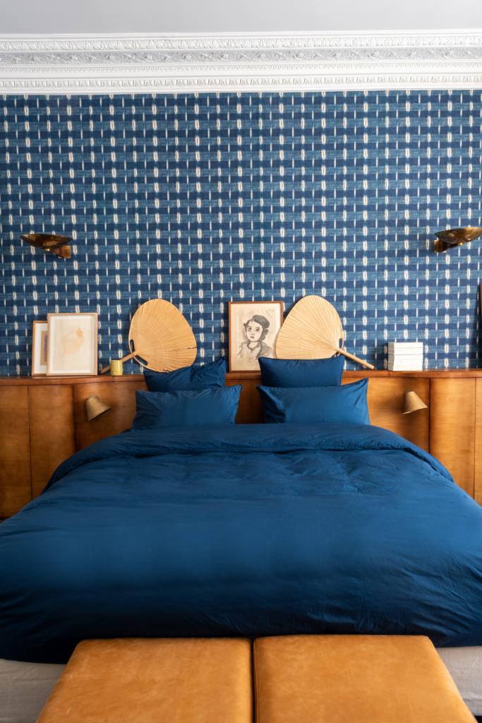 Het behangpapier in de slaapkamer is Flammé Indigo 83A van Antoinette Poisson. De Uchiwa-waaierlampen zijn van Ingo Maurer.