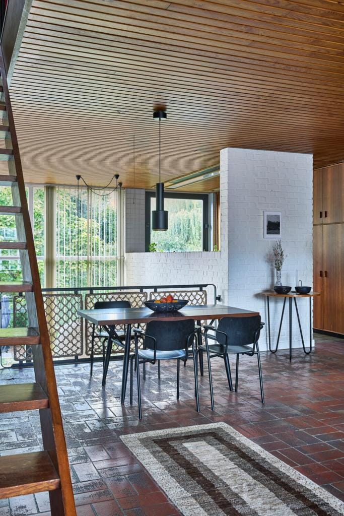 De eetkamerstoelen in staal en hout die de bewoners bijeenzochten, zijn originele ontwerpen van Van Der Meeren voor Tubax.
