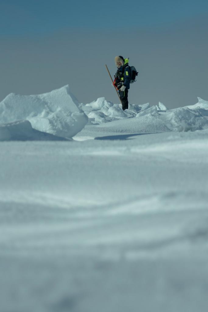 Expeditieleden meten met lange metalen stokken de dikte van het ijs in Groenland.