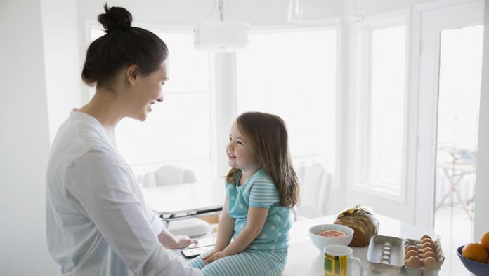 Mother and daughter in pajamas in morning kitchen