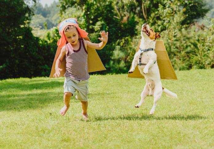 Two friends playing high flyers with cardboard wings © iStock