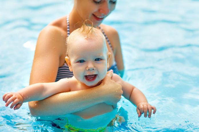 Mother and baby swim in pool