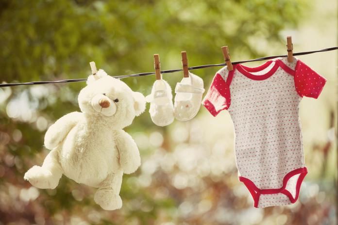 Baby clothes and teddy bear hanging on the clothesline