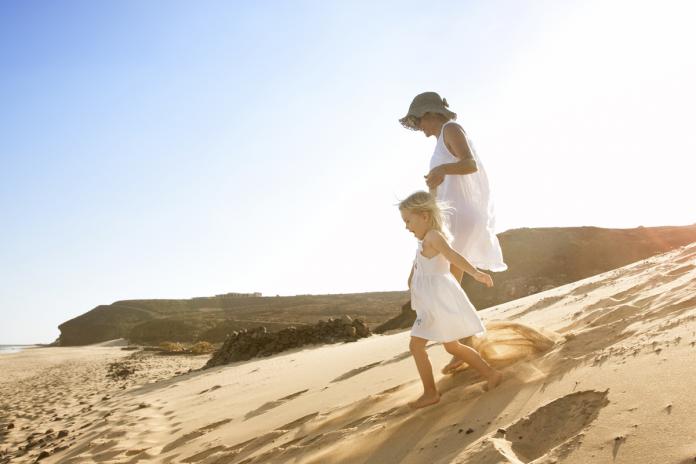 Spain, Fuerteventura, mother running with daughter on the beach