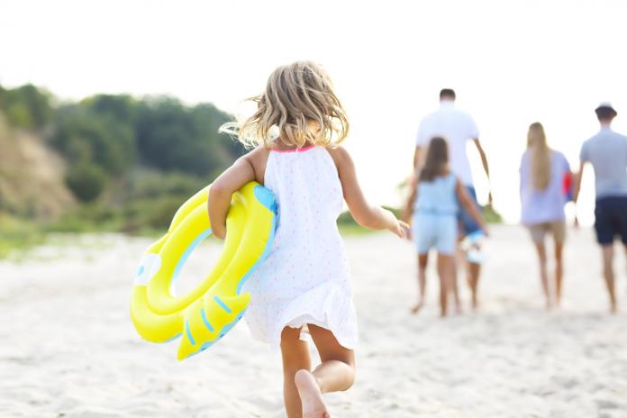 Young blonde girl running on the beech