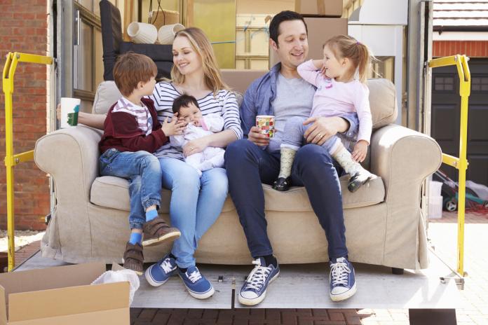 Family With Sofa On Tail Lift Of Removal Truck Moving