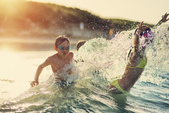 Kids having extreme splashing fun in the sea waves