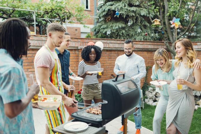 Young People Eating At Barbecue Party.