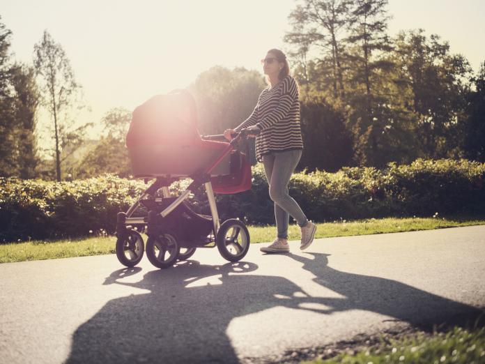 Young mother and her baby in baby carriage