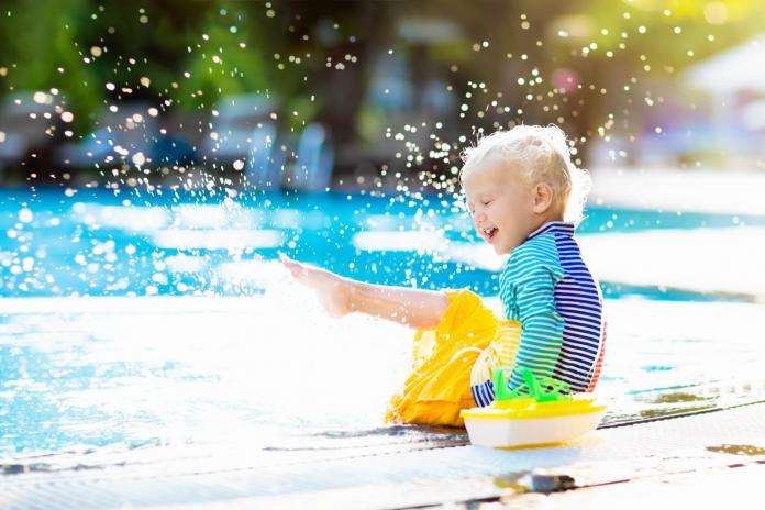 Baby in swimming pool. Family summer vacation.