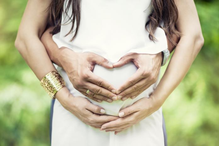Couple Hand Make Heart Symbol on Pregnant Wife Stomach
