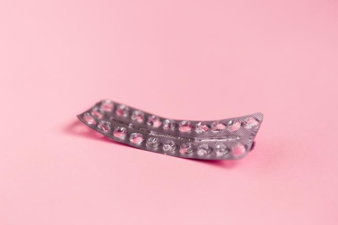 Empty strip of birth control pills on pink
