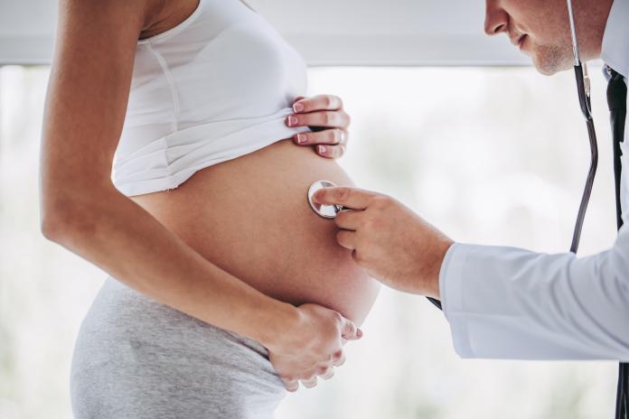 Pregnant woman with doctor.