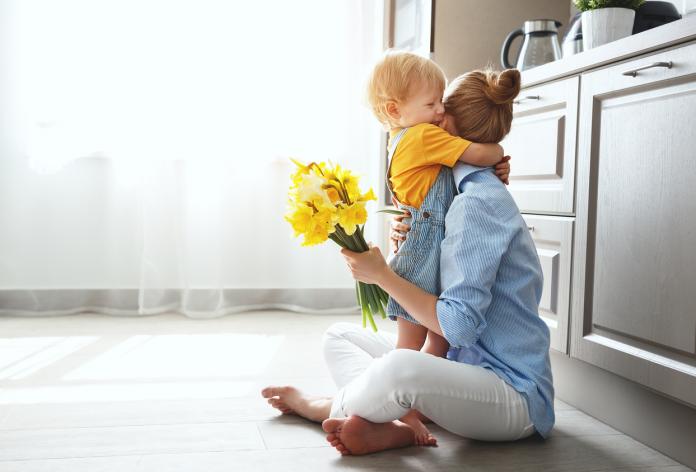 happy mother's day! baby son gives flowersfor mother on holiday