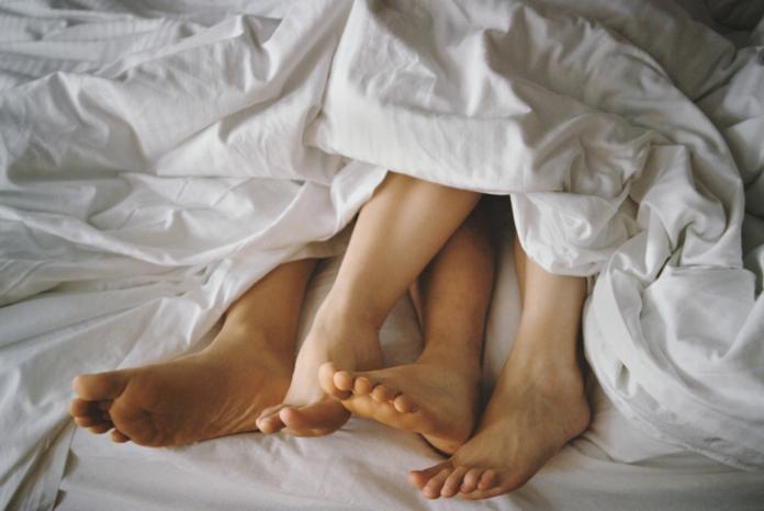 Couple's Feet Entangled in Bed