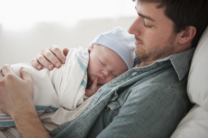 Caucasian father holding baby