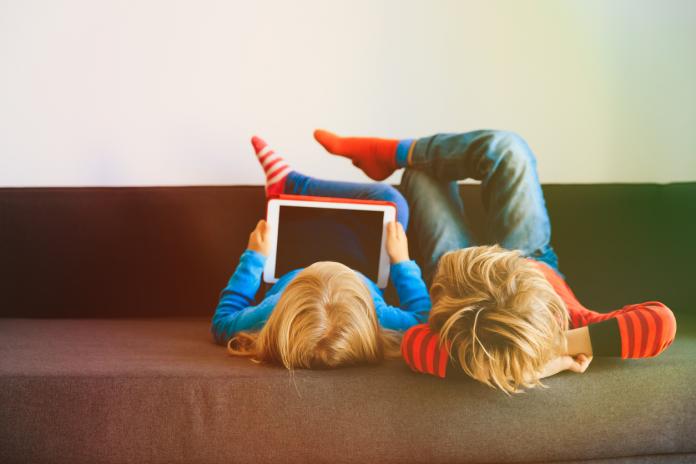 little boy and girl looking at touch pad at home