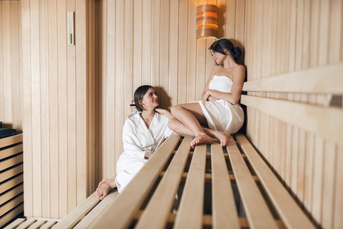 Two beautiful women relaxing in a sauna