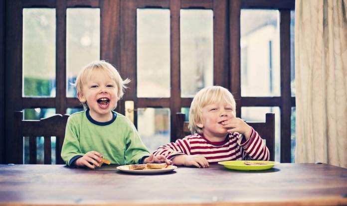Two little boys eating toast for breakfast