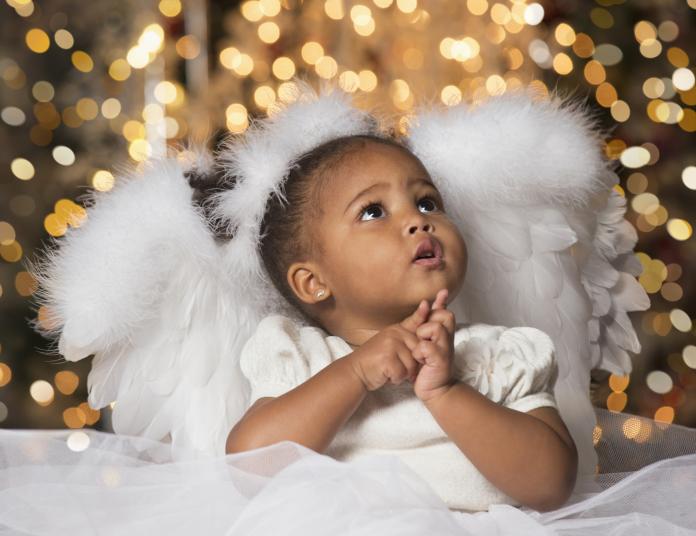 Mixed race girl wearing angel costume