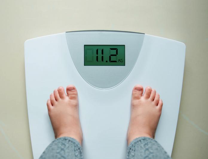 Low Section Of Child Standing On Weight Scale gewicht kind