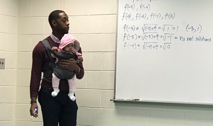 Un professeur enseigne avec un bébé dans les bras pour une bonne raison