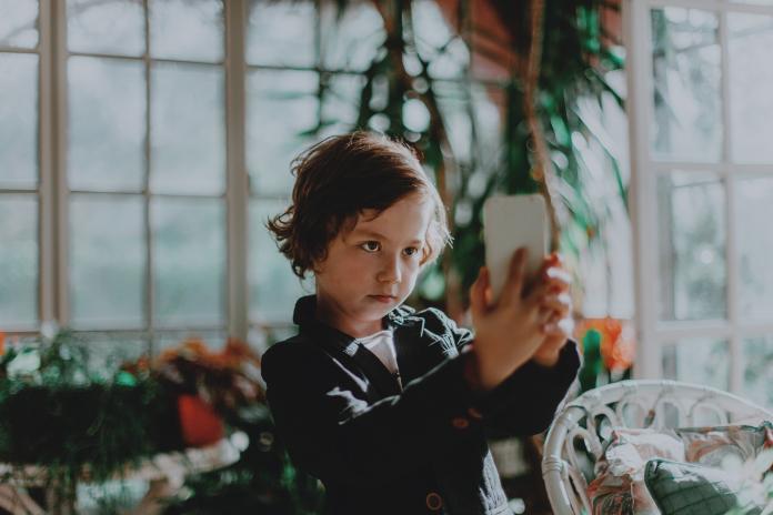 little boy with smartphone taking pictures