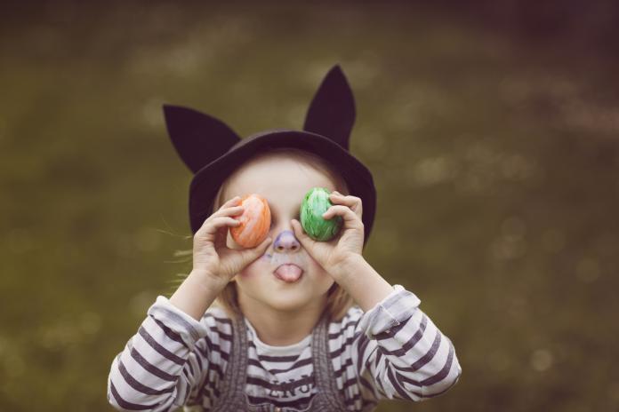 Cheeky girl with rabbit ears and painted easter eggs. pasen