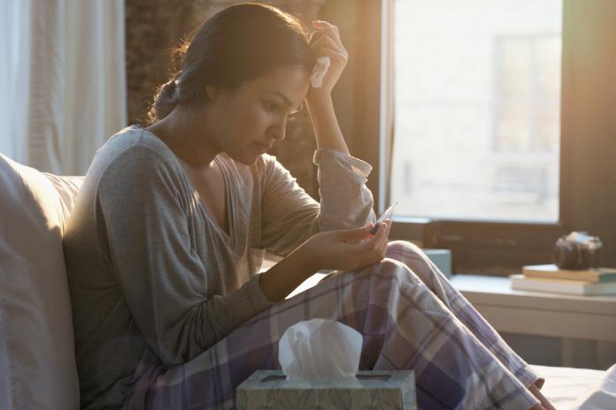Hispanic woman holding tissue reading pregnancy test zwanger worden