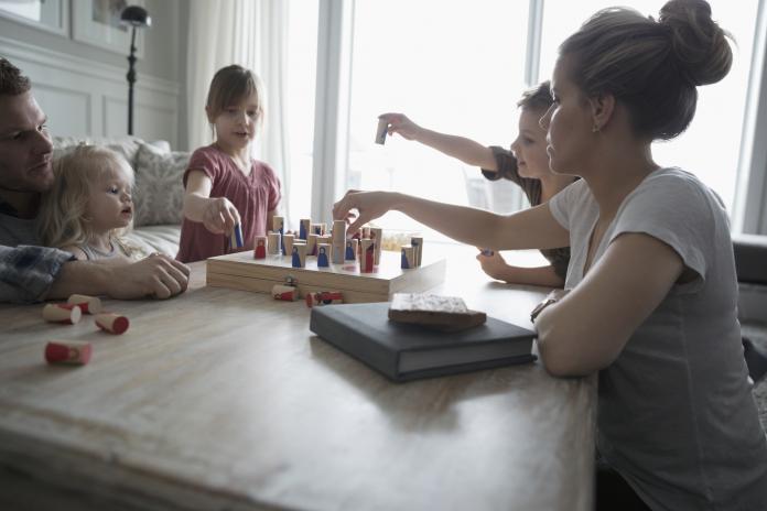 Young family playing game in living room