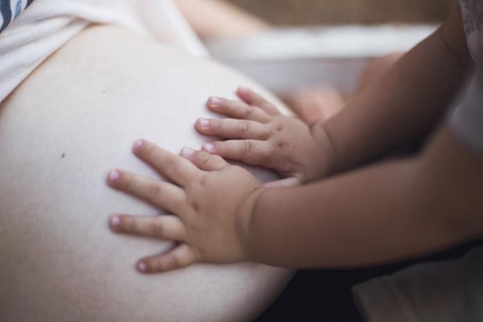 Baby hands in pregnant belly zwanger