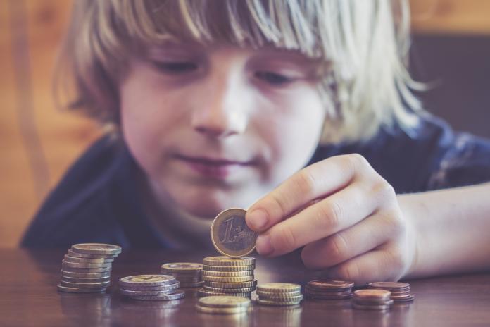 Little boy counting coins kinderen en geld