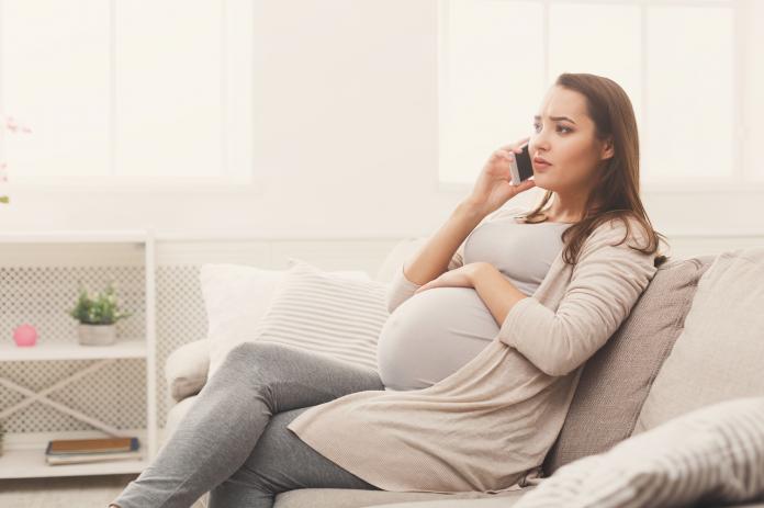 Worried pregnant woman talking on her smartphone weeënremmers