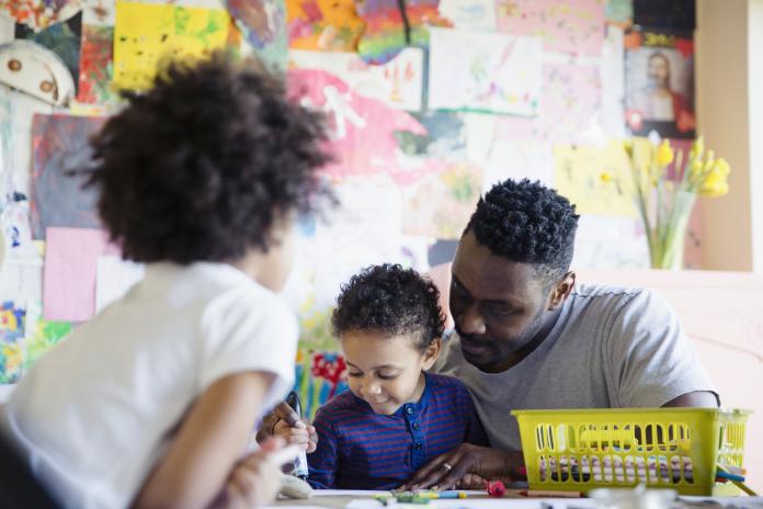 Father and toddler children coloring at table