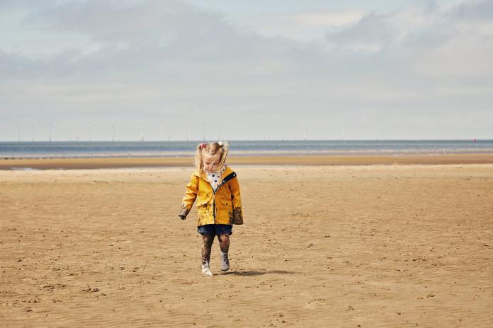 Child walking on the beach zomerjas meisje