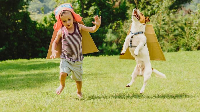 Two friends playing high flyers with cardboard wings © iStock