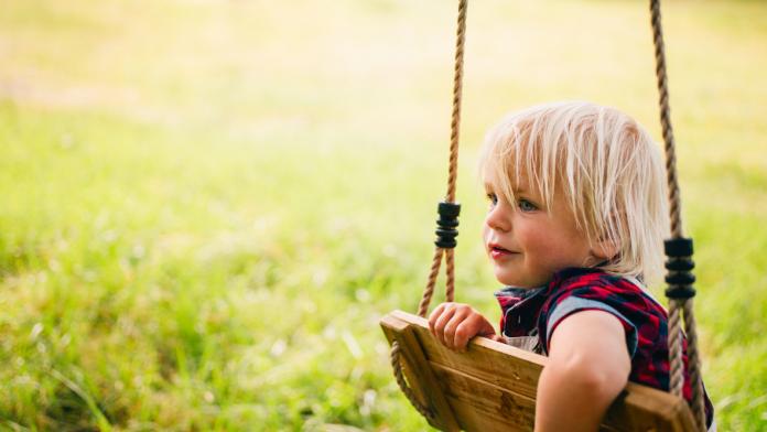 Mischievous child plays with a swing at park
