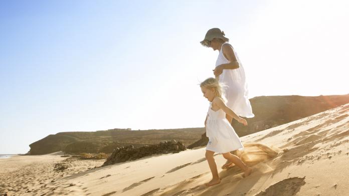 Spain, Fuerteventura, mother running with daughter on the beach