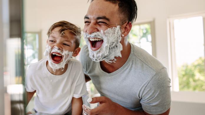 Father and son having fun while shaving in bathroom