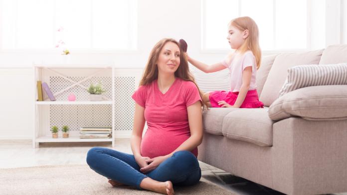 Daughter combing her mother's hair at home