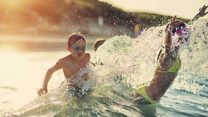 Kids having extreme splashing fun in the sea waves
