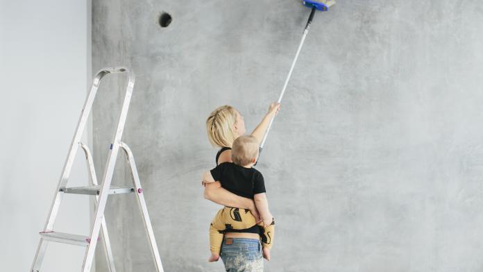 Young woman with son painting wall