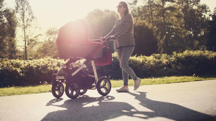 Young mother and her baby in baby carriage