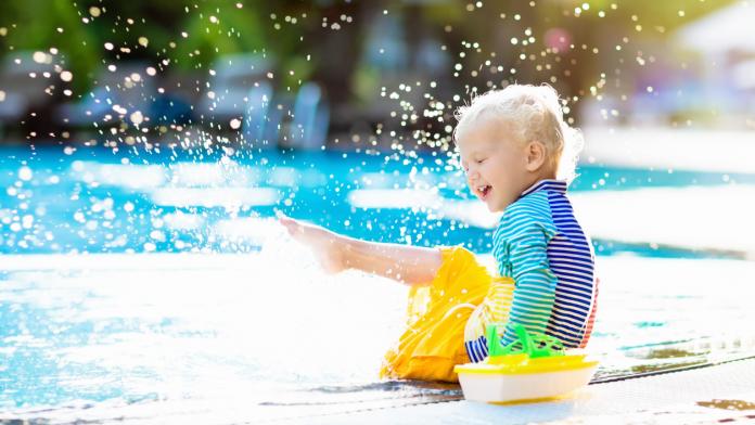 Baby in swimming pool. Family summer vacation.